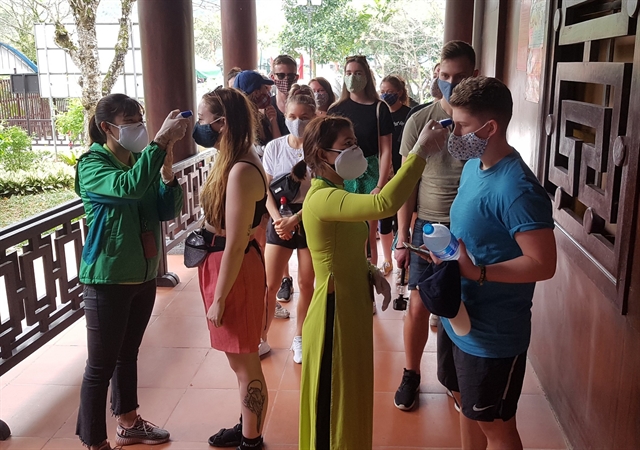 Staff at Tràng An ecotourism complex in the northern province of Ninh Bình check the temperatures of all tourists to the site and asked them to wear face masks